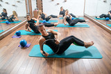 Attractive girls in sportswear training with pilates rings during exercise class in health club