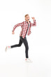 © Drobot Dean - Full length photo of active teen man 17y wearing plaid shirt and jeans running and displaying good results, isolated over white background