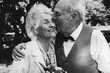 © Vadym - Old couple is walking in the green park. Grandmother and grandfather at their golden wedding anniversary celebration. Fifty years together love story. Grandma and grandpa kissing. Black and white.