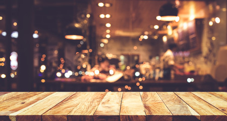 Wall Mural - Wood table top (Bar) with blur night cafe background