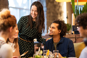 Poster - leisure and people concept - happy friends eating at restaurant