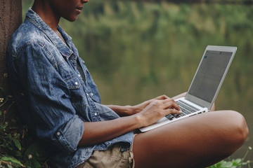 Wall Mural - Woman alone in nature using a laptop