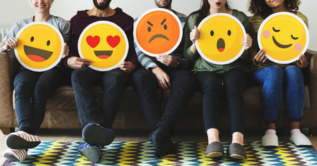 group of diverse people holding emoticon icons