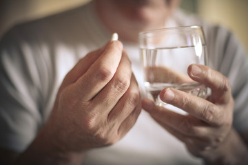 Old man taking a pill.