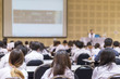 © Chinnapong - Speaker giving educational seminar, school lecture, or entrepreneurship business talk  blur background in conference meeting  with audiences or students in back of the room