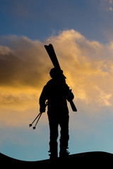 Wall Mural - man with ski equipment at sunset