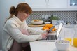 © Wavebreak Media - Woman using laptop in kitchen