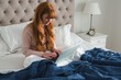 © Wavebreak Media - Woman using laptop in bedroom