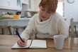 © Wavebreak Media - Woman writing on a diary at home