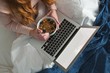 © Wavebreak Media - Woman using laptop while having breakfast in bedroom