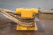 Old Mooring Bollard With Rope Tied On Pier