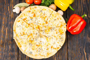 Wall Mural - High angle view of vegetables, dill and parsley around pizza four cheeses