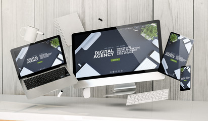 Wall Mural - floating devices at the office with digital agency homepage on screen