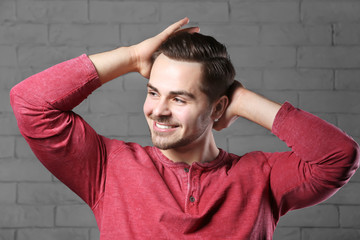 Wall Mural - Portrait of young man with beautiful hair on brick wall background