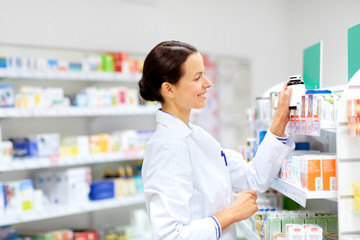 Sticker - medicine, pharmaceutics, healthcare and people concept - happy female apothecary taking drug from shelf at pharmacy