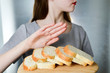 Gluten intolerance concept. Young girl refuses to eat white bread - shallow depth of field