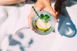 © Dulin - Overhead view of a human hand holding fresh mojito cocktail
