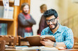 © proimagecontent - Successful bearded student wears glassses reads book in the library reading hall