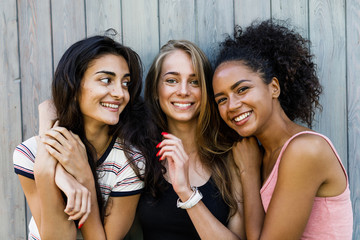 Three beautiful women standing together, having fun 