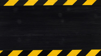 under construction concept background. warning tape frame on black wooden surface background with co
