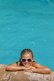 Fototapeta  - Pretty smiling girl in swimming pool on resort