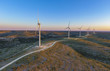 © Cavan Images - Windmills at farm against dramatic sky during sunset