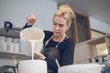 © Cavan Images - Woman pouring paint in container at workshop
