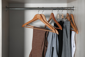 Wall Mural - Hangers with different clothes in wardrobe closet