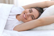 © rogerphoto - Beautiful young and happy woman sleeping while lying in bed comfortably and blissfully smiling