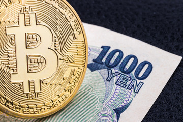 Wall Mural - Close-up of a golden bitcoin on 1000 Yen banknote background