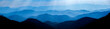 Leinwandbild Motiv Beautiful landscape of blue mountains layers during sunset with sunrays