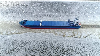 cargo ship sailing through ice aerial shot