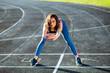© Iryna - Fitness woman jogger warming up before marathon on on stadium.