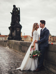 Groom and bride in charles bridge. winter wedding in Prague