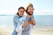 © pressmaster - Young cheerful couple enjoying summer weekend on the beach on sunny day
