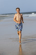 © travelview - boy enjoys running along the beach