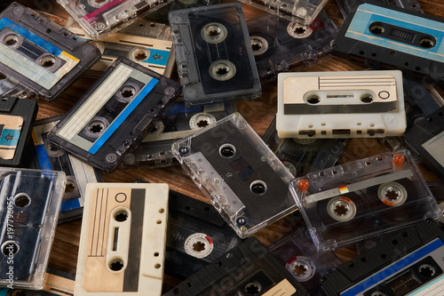 Stampe Large collection of retro cassette tape on old wooden table background, close-up