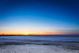Fototapeta Dmuchawce - Frozen ocean at sunset - Baltic sea sunset with frozen sea and snow taken at beach in Tallinn, Estonia