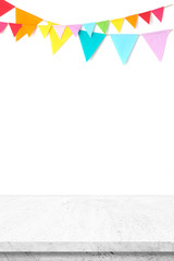 Colorful party flags hanging on white wall and white cement table background, birthday, anniversary, celebrate event, festival greeting card background