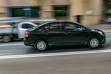 Car in motion on the road, Sydney, Australia. Car moving on the road, blurred buildings in background.