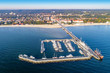 Sopot resort in Poland. Wooden pier (molo) with marina, yachts, pirate tourist ship,  beach, vacation infrastructure, hotels, park and promenade. Aerial view at sunrise.