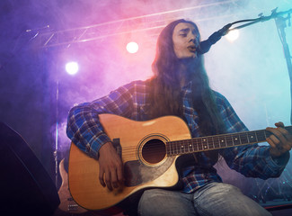 Wall Mural - The musician plays an acoustic guitar.