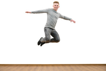 The happy man jumping on the white wall background