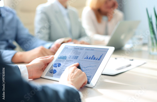 Fotografía Business person analyzing financial statistics displayed on the tablet screen