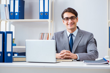 Young handsome businessman employee working in office at desk