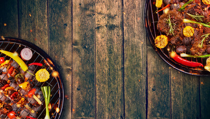 Top view of fresh meat and vegetable on grill placed on wooden floor.