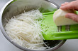 Hand grating white vegetable root into stainless steel bowl