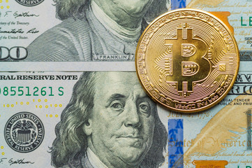 Wall Mural - Golden Bitcoins on US dollars. Digital currency close-up. New virtual money. Crypto currency top view. Real coins of bitcoin on banknotes of one hundred dollars.