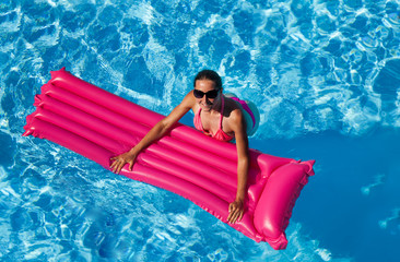 Wall Mural - Happy woman swimming with pink inflatable mattress