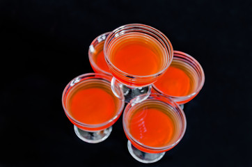 sweet delicious dessert of multi-colored jelly in a glassware isolated on a black background